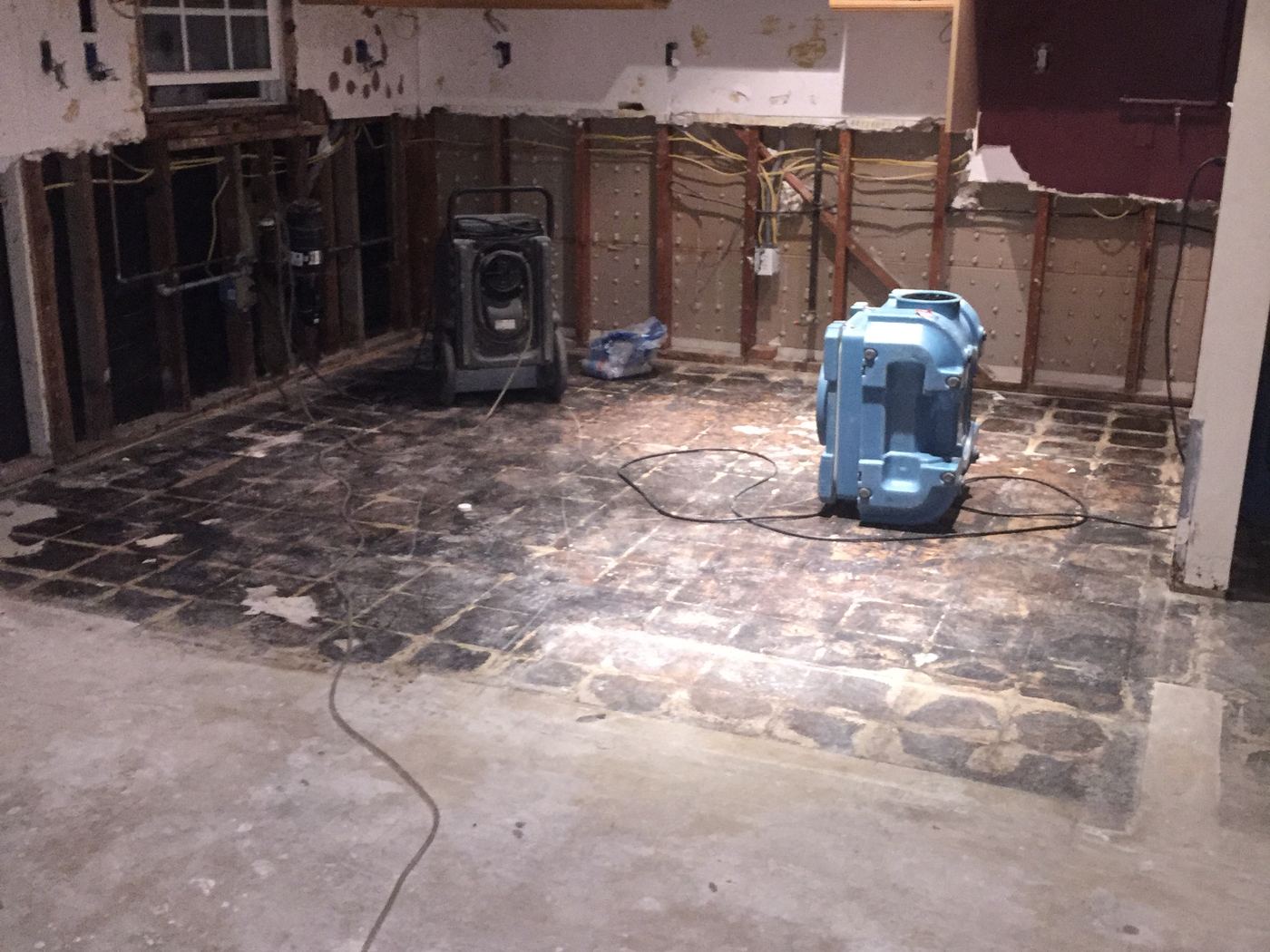 Water-damaged kitchen during demolition with drying equipment