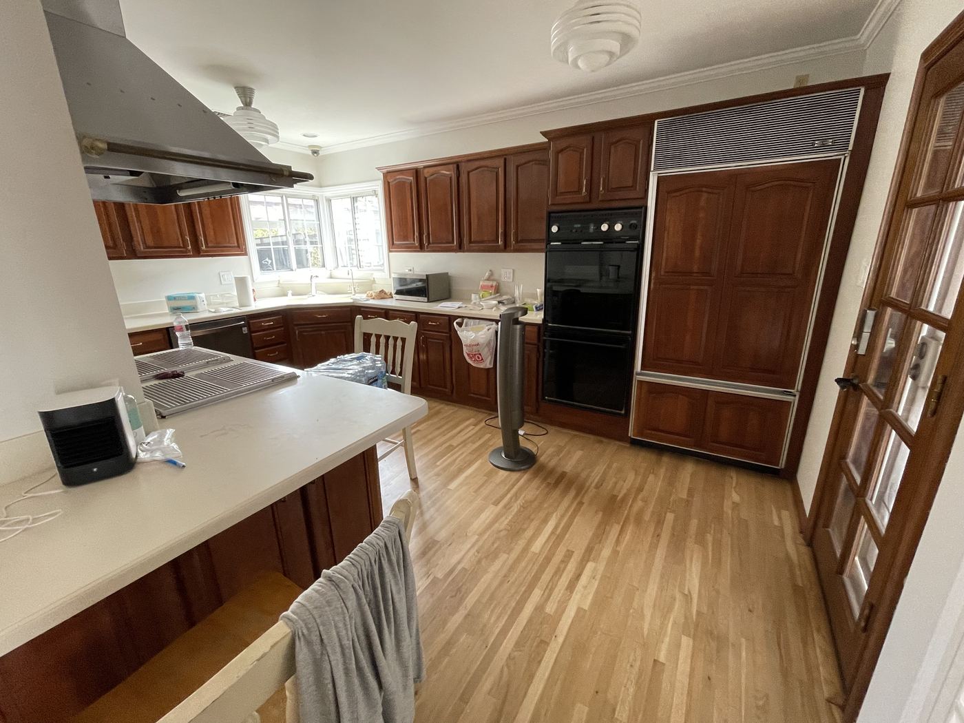 Dated kitchen with dark wood cabinetry and aging black appliances before remodeling